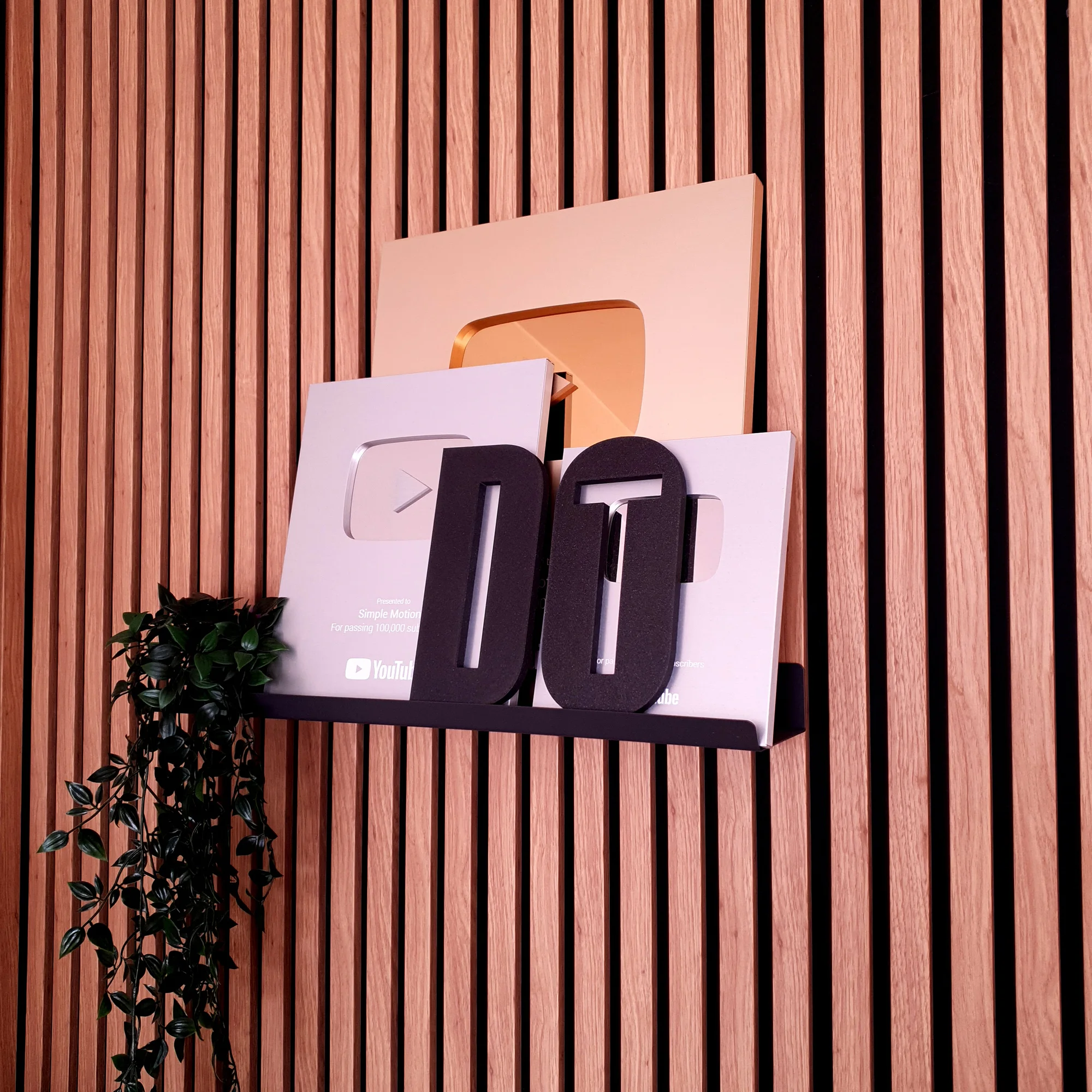 „DO IT“ 3D užrašas prie dekoratyvinės medinių dailylenčių sienos